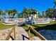 Beautiful community pool area surrounded by palm trees, white fencing, and well-maintained landscaping on a clear sunny day at 6061 Bahia Del Mar Cir # 241, St Petersburg, FL 33715