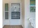 Close up of unit entry with white door and screen, flanked by windows with view to the exterior at 6061 Bahia Del Mar Cir # 241, St Petersburg, FL 33715