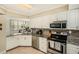 Modern kitchen with granite countertops, stainless steel appliances, and white cabinetry at 6061 Bahia Del Mar Cir # 241, St Petersburg, FL 33715