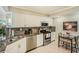 Modern kitchen featuring stainless steel appliances, granite countertops, and white cabinets at 6061 Bahia Del Mar Cir # 241, St Petersburg, FL 33715