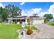 Single-story home features solar panels, well-manicured lawn, and paver driveway at 506 Lime Tree Ct, Sun City Center, FL 33573