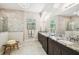 Bright bathroom with a double vanity, granite countertops, modern lighting and marble tile accents at 12532 Lillyreed Ct, Trinity, FL 34655