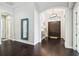 Inviting foyer with hardwood floors, stylish console table, decorative mirror, and double front doors at 12532 Lillyreed Ct, Trinity, FL 34655