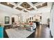 Spacious living room showcasing a coffered ceiling, open layout, and seamless connection to the kitchen and dining areas at 12532 Lillyreed Ct, Trinity, FL 34655