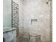 Modern shower with gray tile, marble accents, a built-in bench, and rainfall shower head at 12532 Lillyreed Ct, Trinity, FL 34655