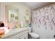 Clean bathroom with floral shower curtain and striped wallpaper at 37827 Mission Hills Ave, Zephyrhills, FL 33541