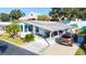 Mobile home with carport, landscaping and a Buick Enclave parked in the driveway at 37827 Mission Hills Ave, Zephyrhills, FL 33541