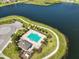 Community pool with surrounding landscaping next to a lake at 928 Royal Empress Dr, Ruskin, FL 33570