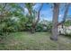 Large backyard with mature trees and a partially visible pool at 2371 Dustin Cir, Spring Hill, FL 34608