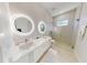 Double vanity bathroom with illuminated mirrors and shower at 4716 Hickory Oak Dr, Brooksville, FL 34601