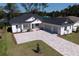 Modern two-story house with a three-car garage and paver driveway at 4716 Hickory Oak Dr, Brooksville, FL 34601