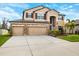 Two-story house with three-car garage and landscaped front yard at 8048 Roma Dune Dr, Wesley Chapel, FL 33545