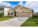 One-story home with tan siding and two-car garage at 15502 Black Pepper Ln, Odessa, FL 33556
