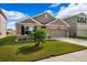 One-story home with tan siding and two-car garage at 15502 Black Pepper Ln, Odessa, FL 33556