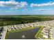 Aerial view of a residential area with houses near a lake featuring a water fountain at 15502 Black Pepper Ln, Odessa, FL 33556