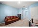 Spacious bonus room with a leather sofa and access to other rooms at 15502 Black Pepper Ln, Odessa, FL 33556