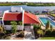 Aerial view of a community pool with covered seating and landscaped grounds by the water at 19111 Vista Bay Dr # 201, Indian Shores, FL 33785