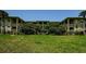 Well-manicured front lawn of a condo complex with lush, mature trees enhancing the landscape's appeal at 2690 Coral Landings Blvd # 722, Palm Harbor, FL 34684