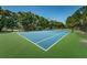Well-maintained tennis court surrounded by lush trees, perfect for sports and recreation at 2690 Coral Landings Blvd # 722, Palm Harbor, FL 34684