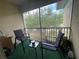 Screened balcony with seating for two and tree views at 6007 Skydale Way # 201, Riverview, FL 33578