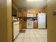 Kitchen with wood cabinets, white appliances, and tile flooring at 6007 Skydale Way # 201, Riverview, FL 33578