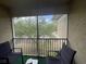 Relaxing screened balcony with treetop views and seating for two at 6007 Skydale Way # 201, Riverview, FL 33578