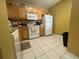 Kitchen with wood cabinets, white appliances, and tile flooring at 6007 Skydale Way # 201, Riverview, FL 33578