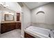 Elegant bathroom featuring a soaking tub, granite countertops, and beautiful dark wood cabinetry at 700 Island Way # 106, Clearwater Beach, FL 33767