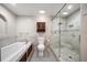 Spa bathroom with glass enclosed shower and relaxing soaking tub at 700 Island Way # 106, Clearwater Beach, FL 33767