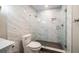 Modern bathroom with marble tile, glass shower, and a sleek, efficient toilet at 700 Island Way # 106, Clearwater Beach, FL 33767