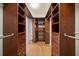 Spacious walk-in closet with custom built-in shelving, drawers, and wood flooring at 700 Island Way # 106, Clearwater Beach, FL 33767