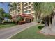 Beautifully landscaped entry way to the building with covered entrance and lush foliage at 700 Island Way # 106, Clearwater Beach, FL 33767