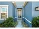 Inviting front entrance with gray door and landscaping at 8852 Prairie Creek Dr, New Port Richey, FL 34655