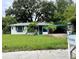 Charming ranch style home with teal accents and lush lawn at 1004 E Fern St, Tampa, FL 33604