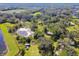 Aerial view showcasing land with a pond and trees at 1810 Curry Rd, Lutz, FL 33549