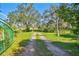 Gravel driveway with lush greenery on either side at 1810 Curry Rd, Lutz, FL 33549
