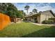 Landscaped backyard, wooden fence, and patio at 2025 Macarthur Ct, Dunedin, FL 34698