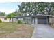 Single-story home with a driveway, attached garage, and landscaped yard at 664 Frederica Ln, Dunedin, FL 34698