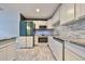 Updated kitchen with white shaker cabinets, granite counters, and a sleek green refrigerator at 664 Frederica Ln, Dunedin, FL 34698
