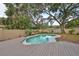 Tranquil pool area with a wooden deck and privacy fence at 664 Frederica Ln, Dunedin, FL 34698