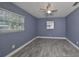 Blue bedroom with updated windows, tile floors, and white baseboards at 664 Frederica Ln, Dunedin, FL 34698