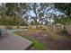Spacious backyard featuring a pool, deck, fire pit, and storage sheds at 664 Frederica Ln, Dunedin, FL 34698