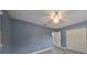 Blue bedroom with white closet doors, gray tile floor and access to a bathroom at 664 Frederica Ln, Dunedin, FL 34698
