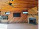 Living room with wood-paneled walls, a fireplace, a TV, and an aquarium at 113 Boca Ciega Dr, Madeira Beach, FL 33708