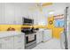 Bright kitchen features white cabinets, stainless steel appliances, and a yellow accent wall at 14900 Gulf Blvd # 410, Madeira Beach, FL 33708