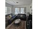 Cozy living room with dark leather sofas, a patterned rug, and natural light from the windows at 3102 W Leroy St # A, Tampa, FL 33607