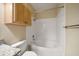 Clean bathroom with a bathtub and overhead wood cabinet at 5000 Culbreath Key Way # 1-203, Tampa, FL 33611