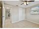 Cozy bedroom with ceiling fan, tile floors, and access to hallway at 3525 Umber Rd, Holiday, FL 34691