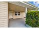 Covered entryway with white door, window, and lush landscaping at 3525 Umber Rd, Holiday, FL 34691