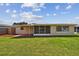 Back of house showing screened porch and yard at 3525 Umber Rd, Holiday, FL 34691